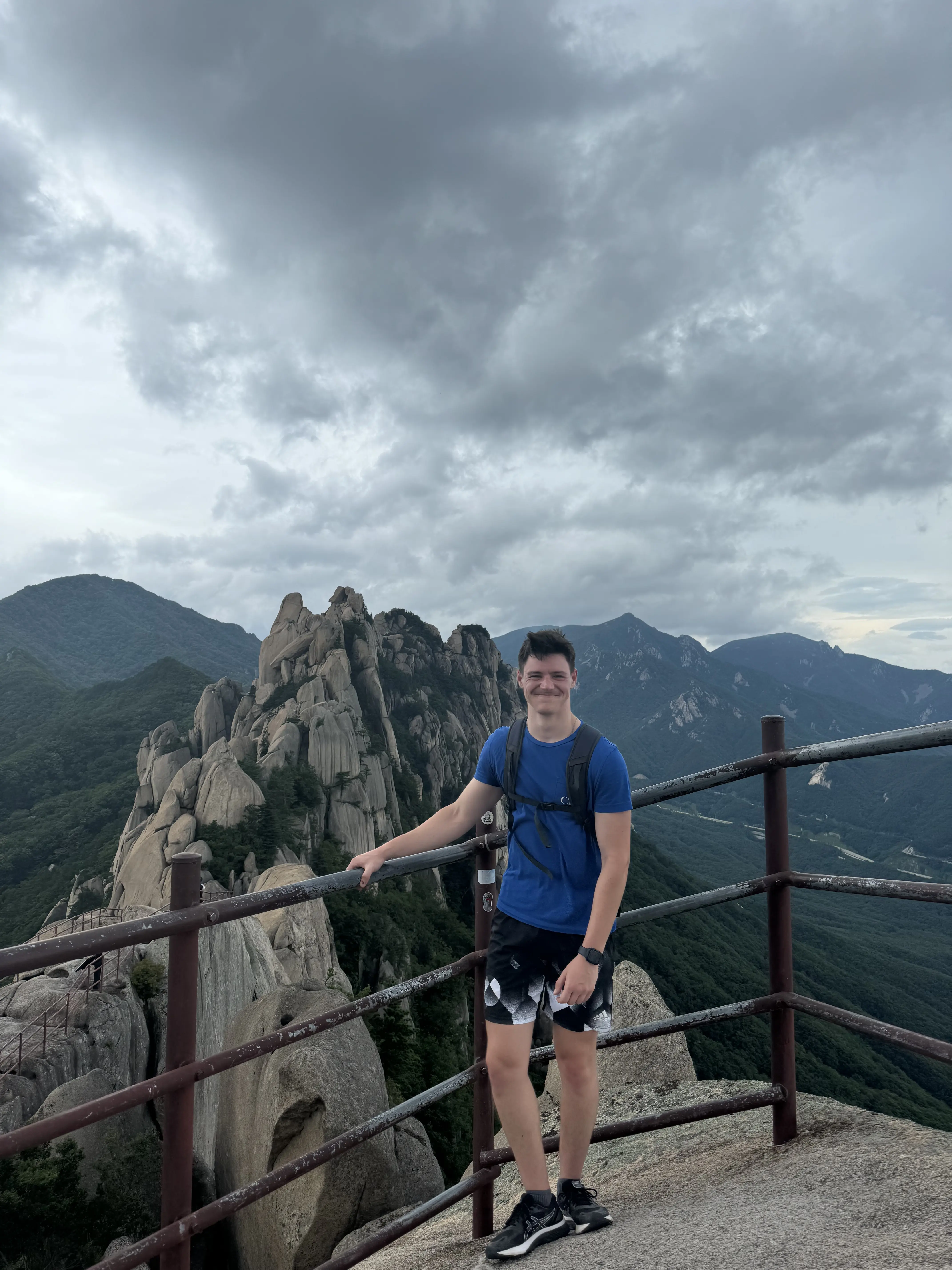 Portrait de Raphaël lors d'un voyage, souriant devant un paysage urbain